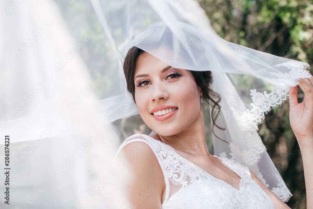 Beautiful bride with stylish make-up in white dress in spring garden Beautiful bride with stylish make-up in white dress in spring garden