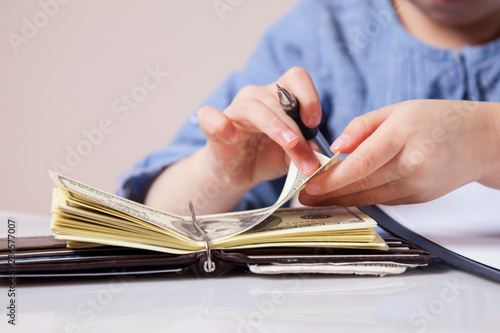 Little cute child girl counting money. Success, business, wealth concept.