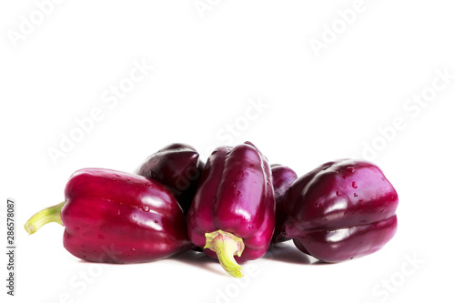 five violet peppers on a white background