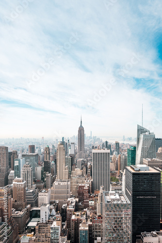 New York City Manhattan, NYC/ USA - 08 21 2017: Top of the Rock panorama view over skyline from Rockefeller center to NYC and the Empire State building on a light cloudy sunny day with blue sky