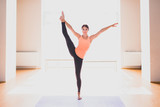 Young beautiful brunette woman making stretching exercises in a light studio. Well being, wellness concept.