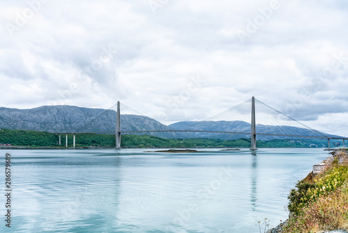 Panoramic sideview photo of Helgelandsbrua  norwegian  or Helgeland Bridge is Norway s finest bridges between Alstahaug and Leirfjord at Helgeland  Norway. Cloudy and quiet summer weather