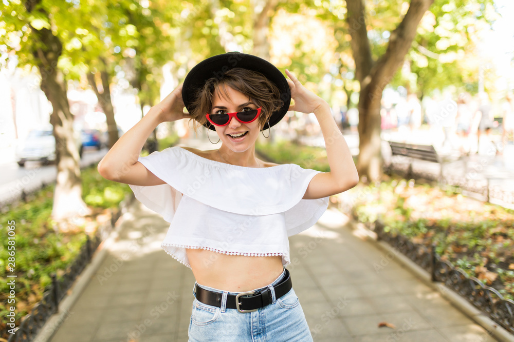 Portrait of beautiful smiling young woman in hat, against background of summer green park. Portrait of beautiful smiling young woman in hat, against background of summer green park.