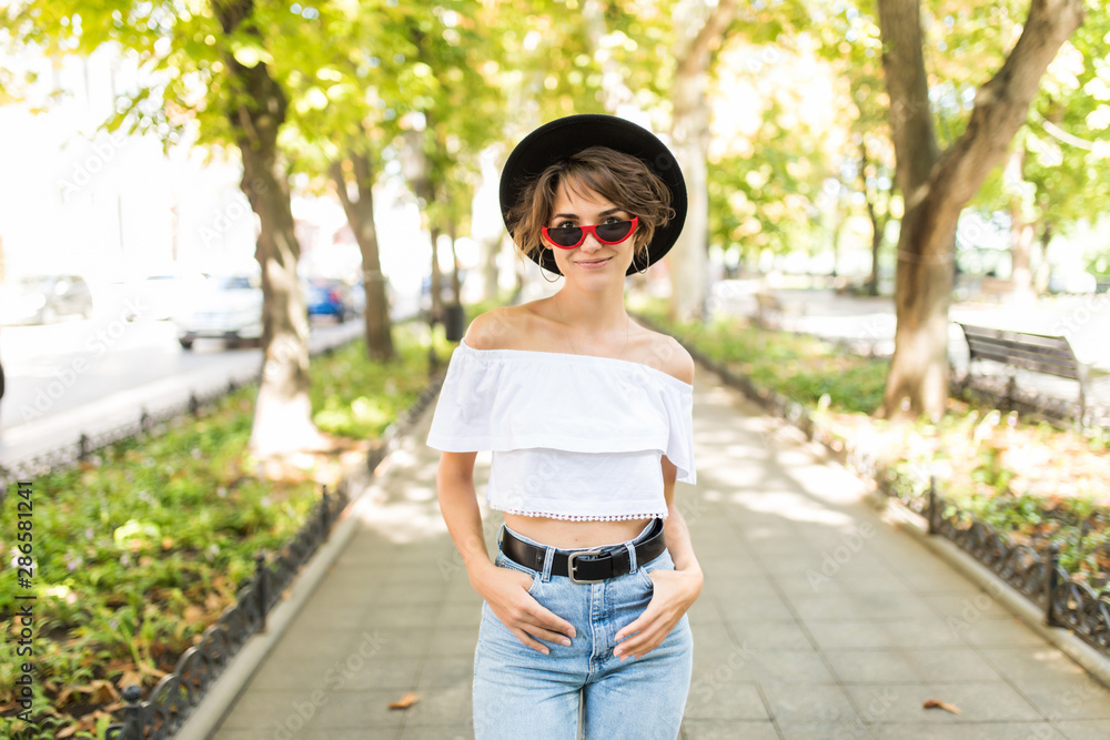 Portrait of beautiful smiling young woman in hat, against background of summer green park. Portrait of beautiful smiling young woman in hat, against background of summer green park.