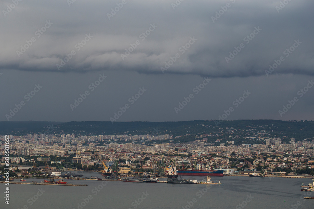 Fototapeta premium The city of Varna during the storm. The downpour is approaching the sea coast. The Bulgarian resorts in the summer. European recreation area. Thunderhead covers the city.