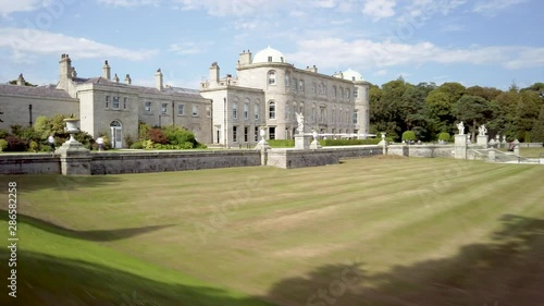 Powerscourt House & Gardens hyperlapse tour through tourists visiting historic real estate grounds. photo