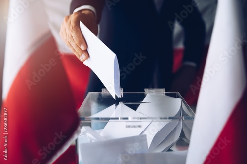 Man putting his vote do ballot box. Political elections photo
