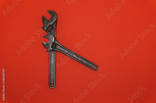 Old metal wrenches on a red background