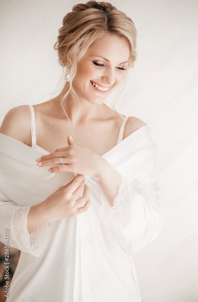Beautiful blonde bride with stylish make-up in white dress.Morning bride Beautiful blonde bride with stylish make-up in white dress.Morning bride
