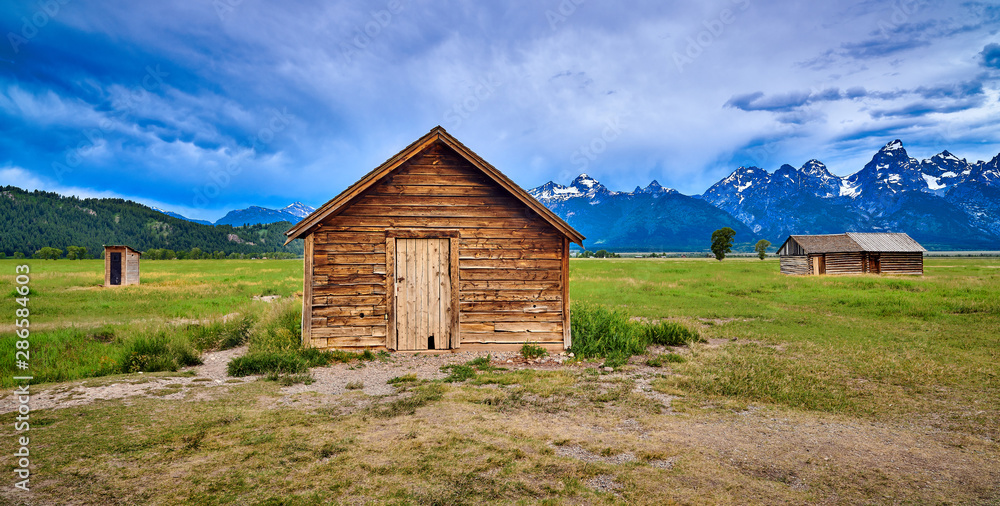 Storm clouds with outhouse, pumphouse and granary. Mormon Row, Grand Teton National Park. Storm clouds with outhouse, pumphouse and granary. Mormon Row, Grand Teton National Park.