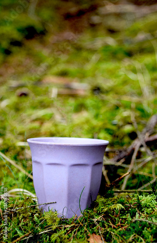 Coffee mug on the green moss in the forest