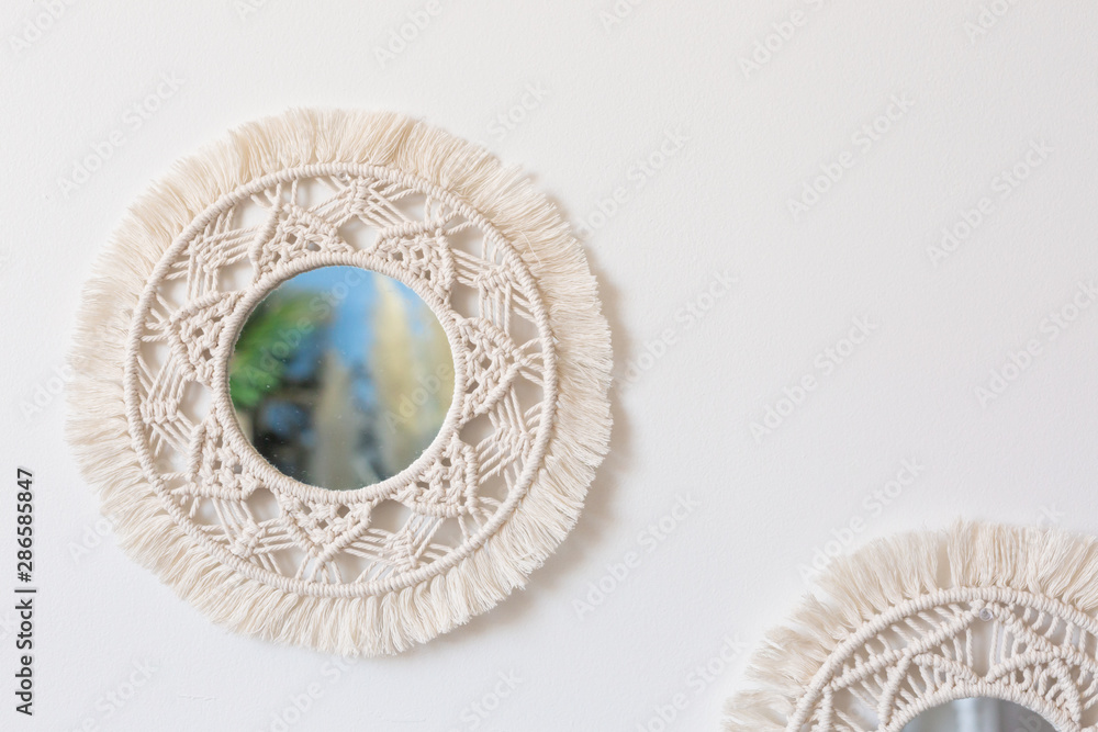 Fotografie Two woven macrame mirrors on a white wall