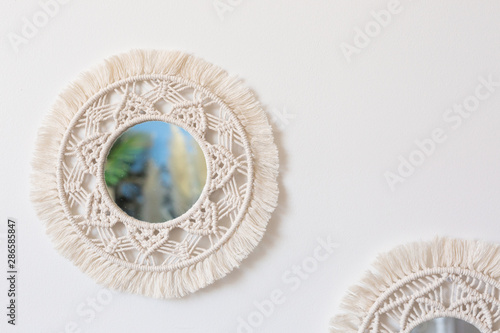 Two woven macrame mirrors on a white wall photo