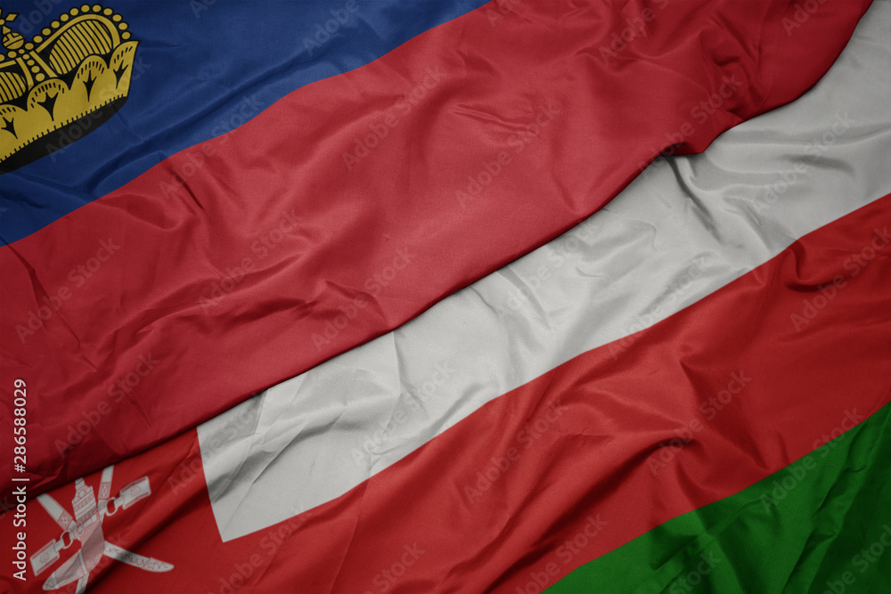 waving colorful flag of oman and national flag of liechtenstein.