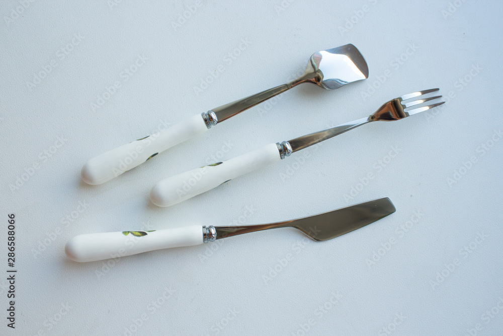 Fototapeta premium cutlery dessertware fork spoon knife on a white background with a rose on the handle