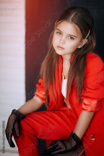 Little happy girl in  red fashion clothes