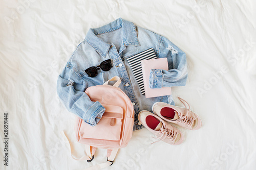 Canvas Print Blue jean jacket pale pink with backpack, book and sneakers on white