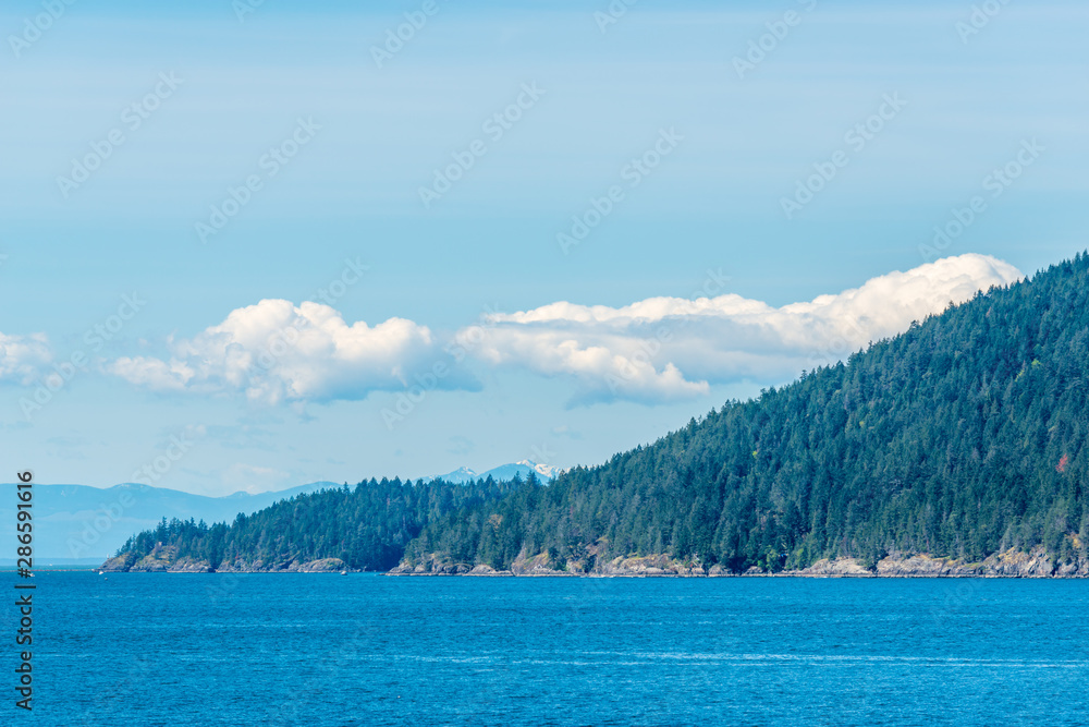 View over Burrard Inlet, ocean and island with boat and mountains in beautiful British Columbia. Canada. View over Burrard Inlet, ocean and island with boat and mountains in beautiful British Columbia. Canada.
