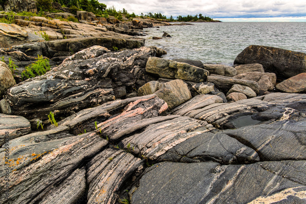 Multibanded gneiss rocks on the shoreline of an island among the 30,000-island archipelago of the Georgian Bay, in Ontario, Canada. Multibanded gneiss rocks on the shoreline of an island among the 30,000-island archipelago of the Georgian Bay, in Ontario, Canada.