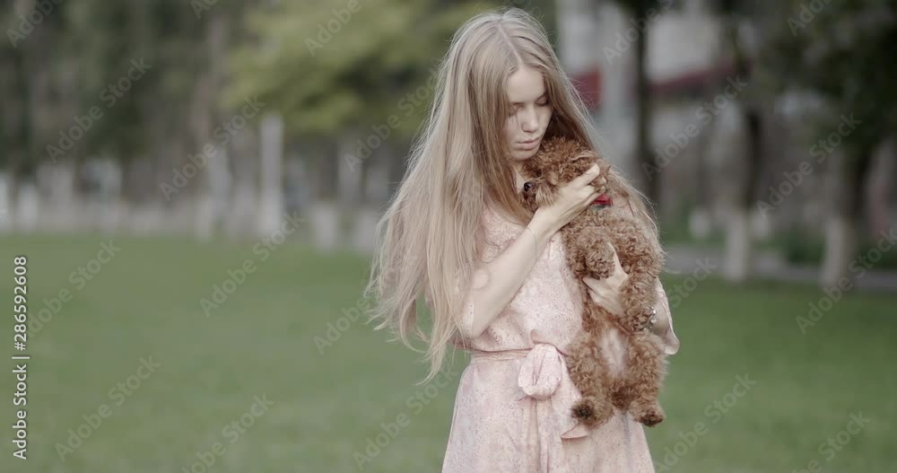Beautiful young girl holding a dog in her arms. Beautiful young girl holding a dog in her arms.