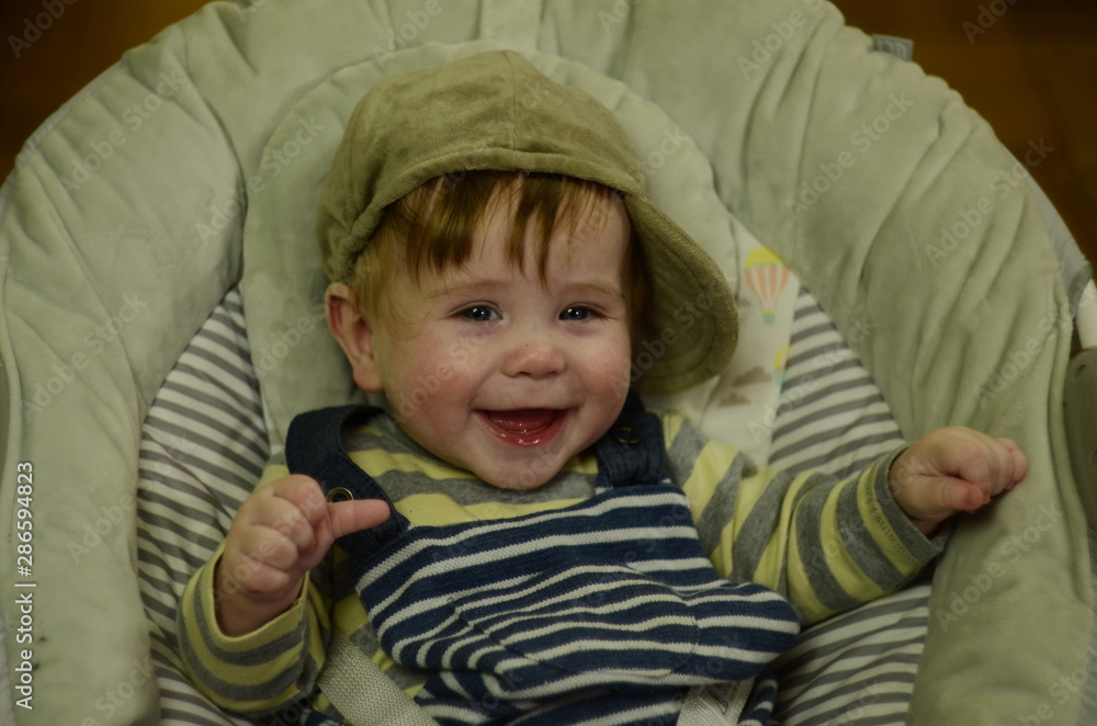 smiling 6 months old boy with gray eyes and blond hair in a striped suit - portrait smiling 6 months old boy with gray eyes and blond hair in a striped suit - portrait