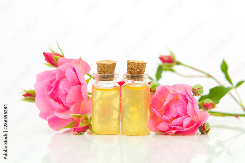 Essence of rose on white background in beautiful glass bottle Essence of rose on white background in beautiful glass bottle