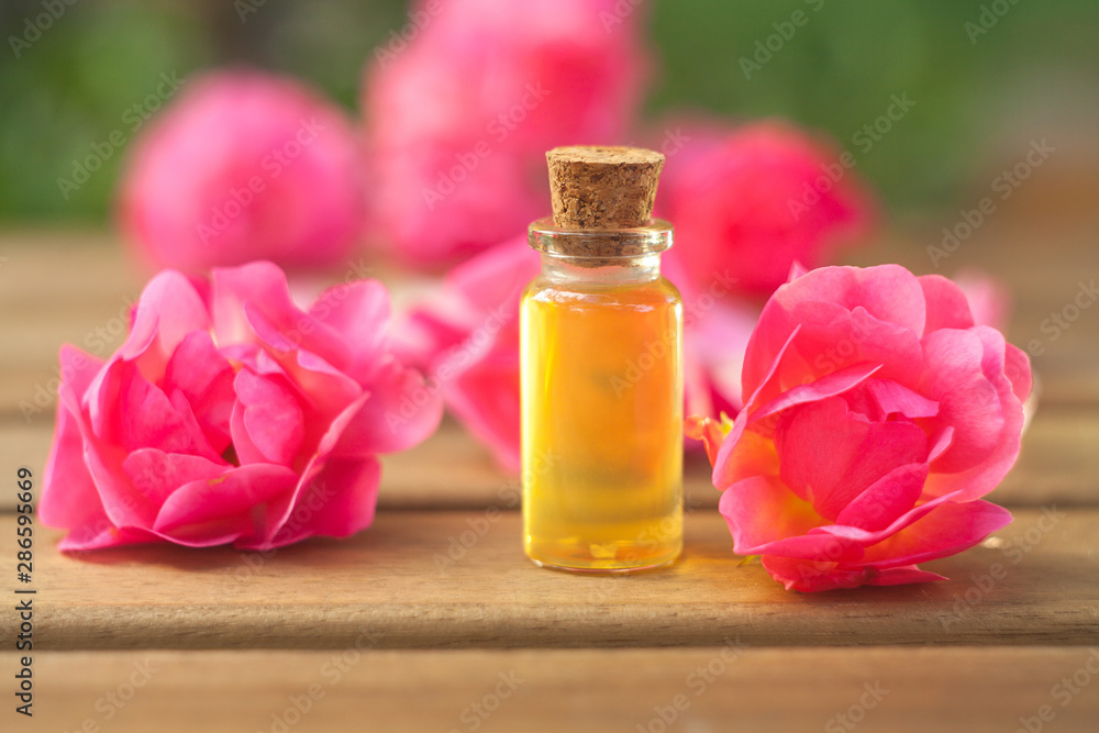 Essence of rose on table in beautiful glass bottle Essence of rose on table in beautiful glass bottle