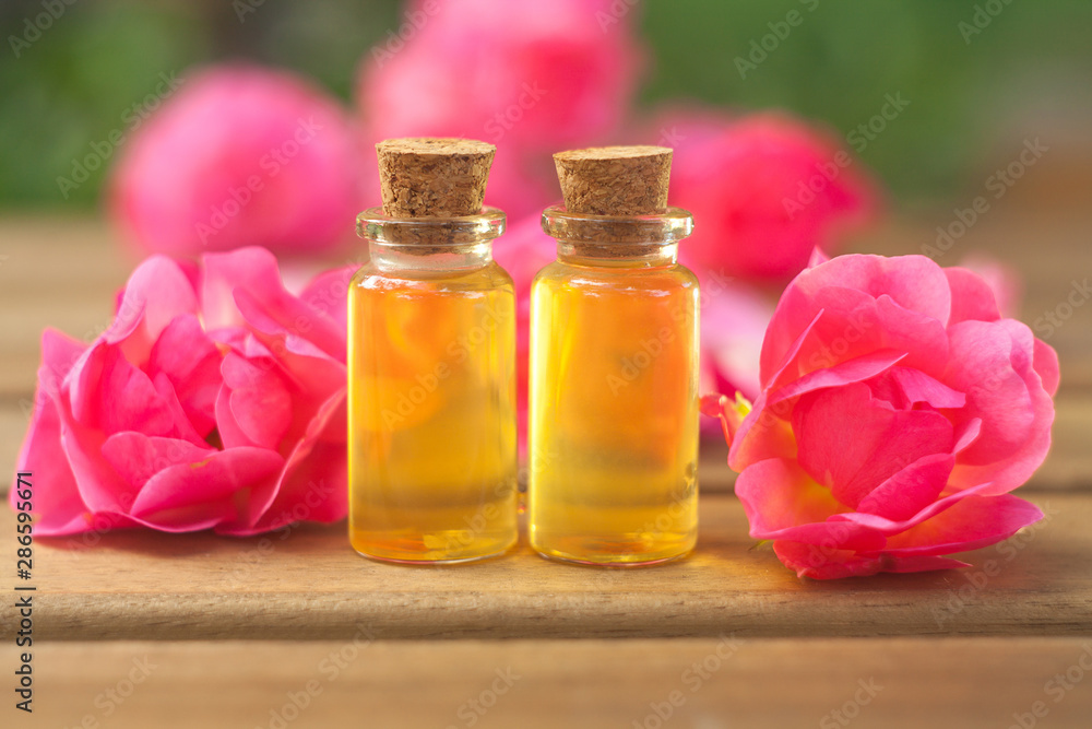 Essence of rose on table in beautiful glass bottle Essence of rose on table in beautiful glass bottle