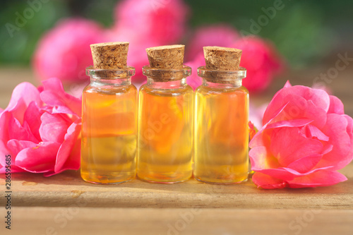 Essence of rose on table in beautiful glass bottle