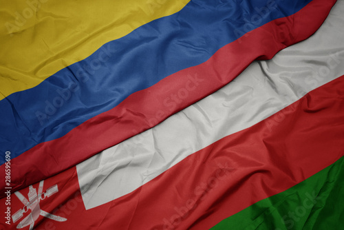 waving colorful flag of oman and national flag of colombia.