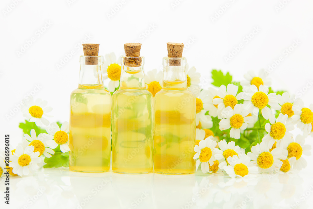 Essence of flowers on table in beautiful glass bottle Essence of flowers on table in beautiful glass bottle