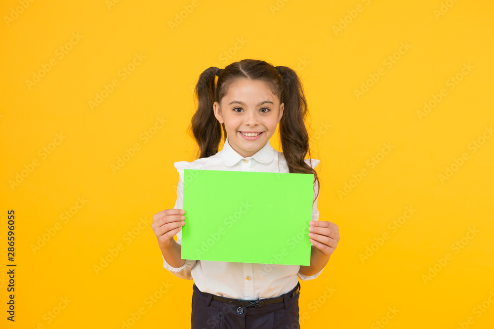 Here is your homework. Adorable small child holding empty homework sheet on yellow background. Cute little girl with blank green school paper for doing homework assignment. Homework, copy space Here is your homework. Adorable small child holding empty homework sheet on yellow background. Cute little girl with blank green school paper for doing homework assignment. Homework, copy space