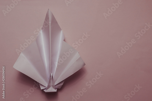 Origami paper bird on color background