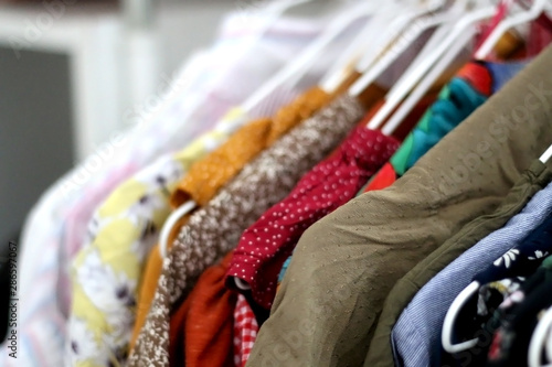 Colorful blouses on a clothing rack. Selective focus, close-up.