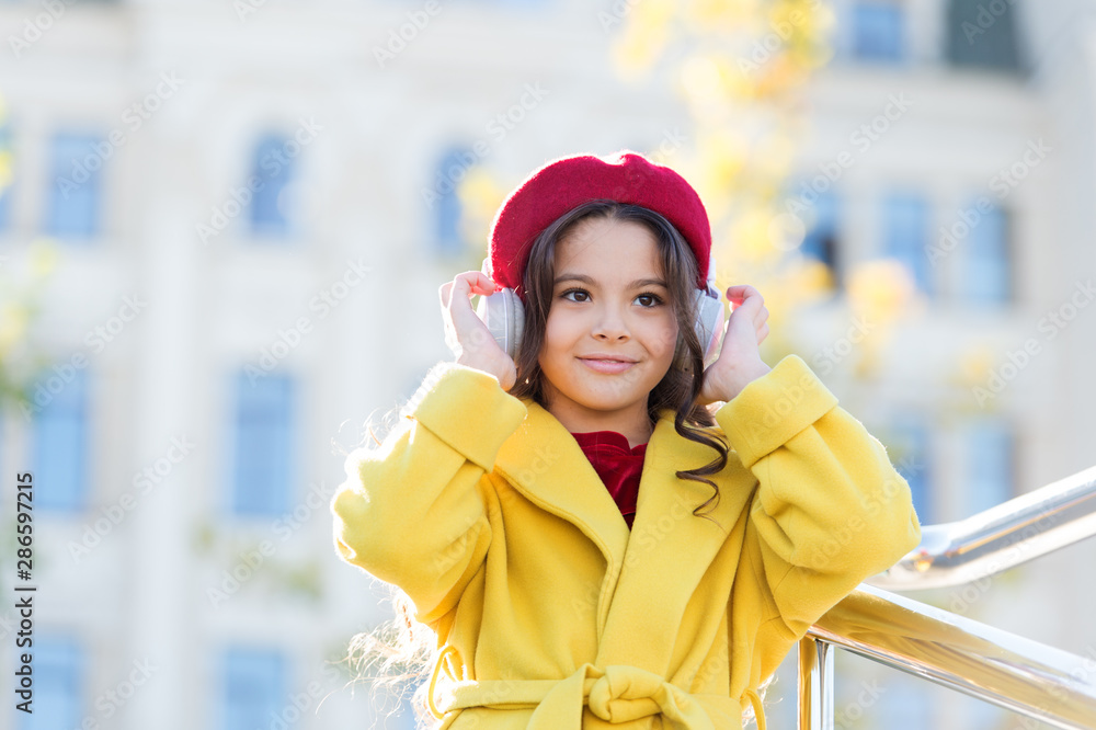 Stereo sound. Child girl autumn outfit enjoying music. Awesome sound. Girl kid with headphones urban background. Little girl listening music enjoy favorite song excellent sound. Good vibes only