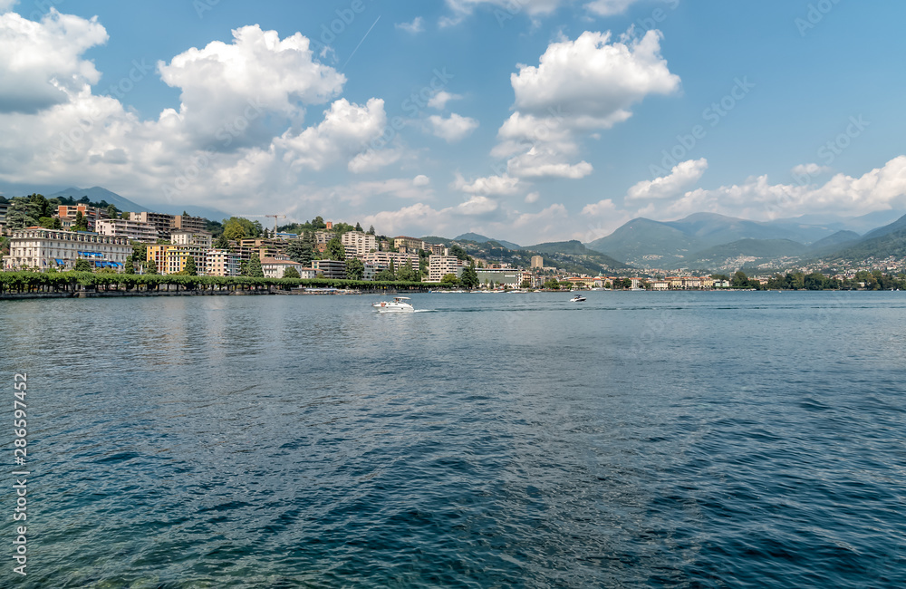 Landscape of Lake Lugano with Lugano city on background in summer day.
