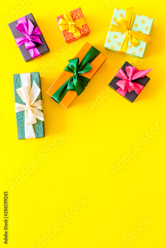 presents in boxes frame on yellow background top view copyspace