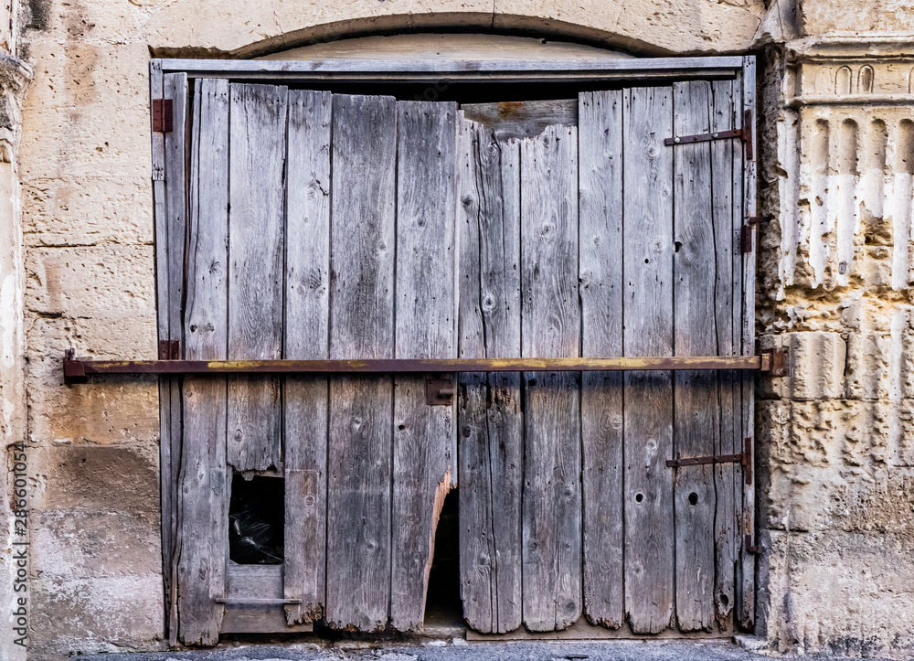 The courtyard of the castle, or ducal palace, of the Castromediano Lymburgh, in Cavallino, Lecce, Puglia, Salento, Italy. Un antico cancello di legno rotto. The courtyard of the castle, or ducal palace, of the Castromediano Lymburgh, in Cavallino, Lecce, Puglia, Salento, Italy. Un antico cancello di legno rotto.