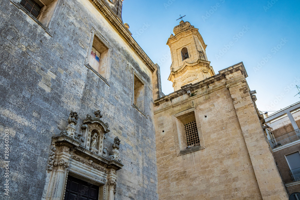 The mother church of Cavallino, Lecce, Puglia, Salento, Italy. In baroque style. The side entrance and the bell tower.
