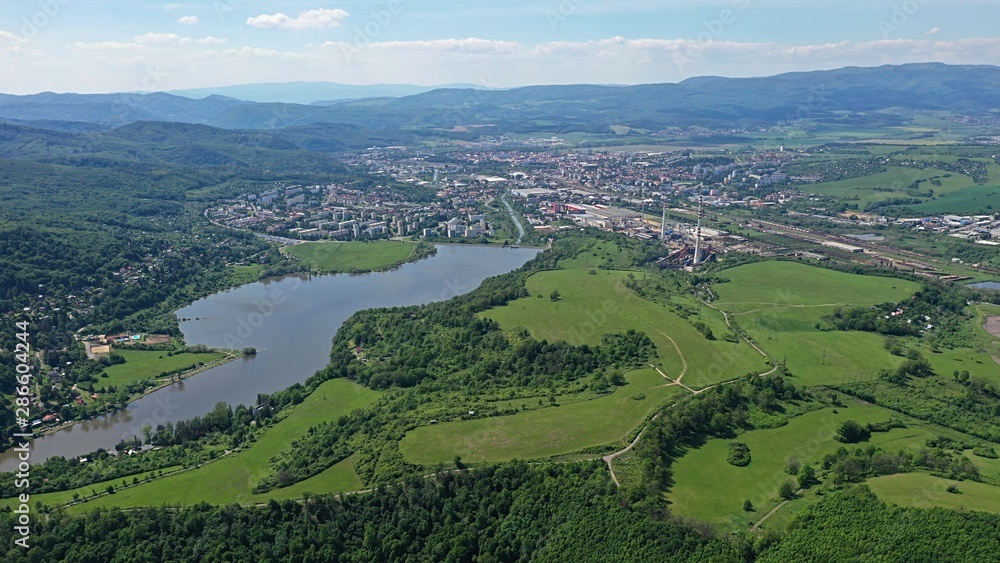 Aerial view of Motova river dam built on Slatina river, forest and meadows in front, Zvolen city and surrounding hills in background. 