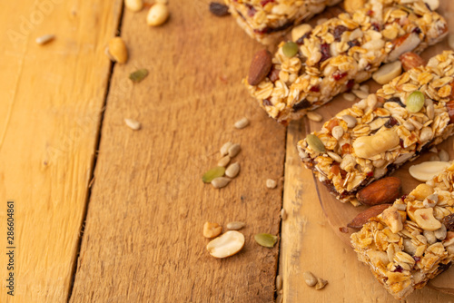 granola bars and nuts on a wooden background with space for design, horizontal photo, diet, proper nutrition