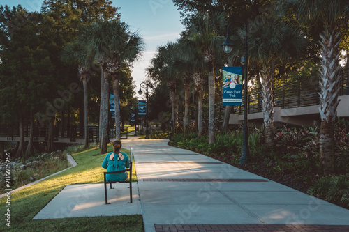 Woman reads on bench at Cranes Roost park in Altamonte Springs a suburb of greater Orlando, Florida