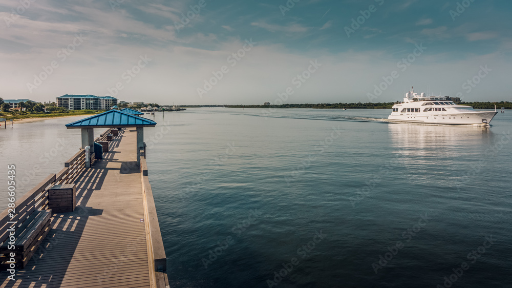 Smyrna Dunes Fishing Pier with Yacht in New Smyrna Beach, Florida Smyrna Dunes Fishing Pier with Yacht in New Smyrna Beach, Florida