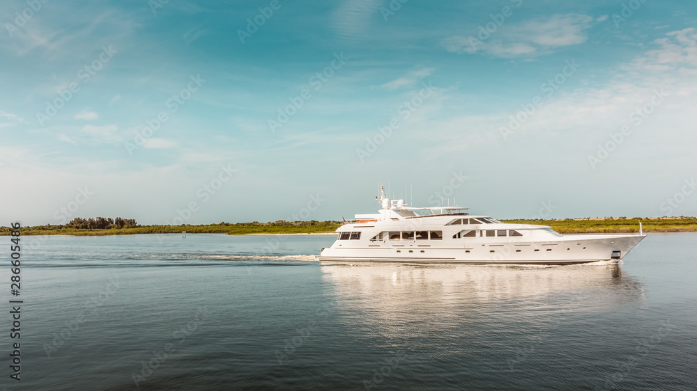 Luxury yacht travels in the Indian River headed to open ocean in New Smyrna Beach, Florida