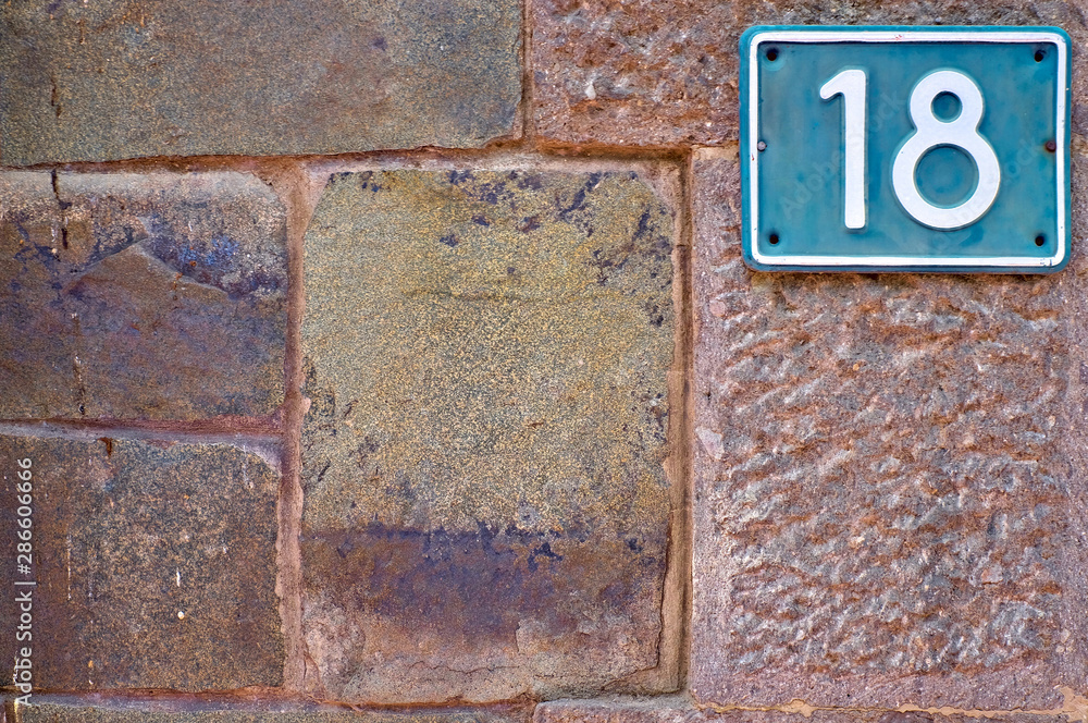 18, number eighteen, numeral plate on stone surface, offset with copy space. 18, number eighteen, numeral plate on stone surface, offset with copy space.