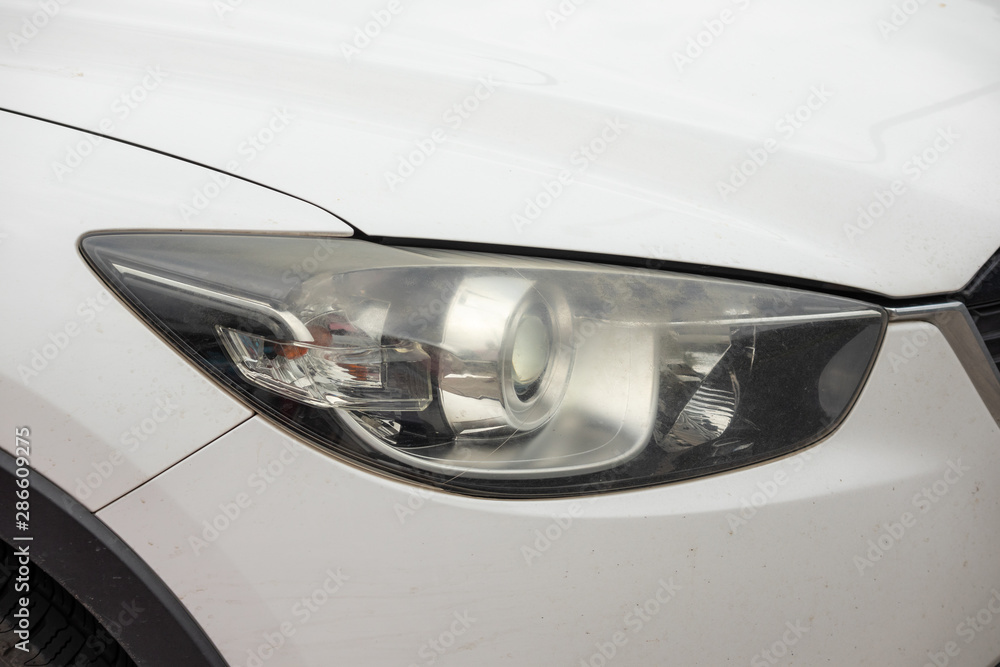 headlights of the car dim from working a long time,blurred headlights on the car,Damaged and blurred headlight surface as a result of weather condition and aging of a car.with copy space
