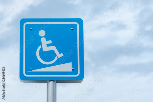 Handicap sign. White symbol over blue background on blue sky background,Ramp for disabled people sign icon in deep blue sky.with copy space.