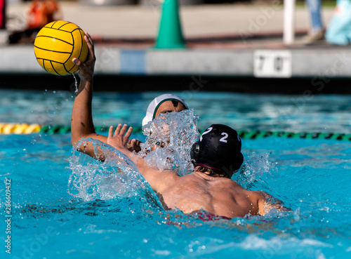 Foto Offensive player in white uniform having water spashed in face as defensive player in black applies pressure
