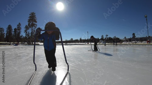 Little boys ice skate on a frozen outdoor rink in the winter