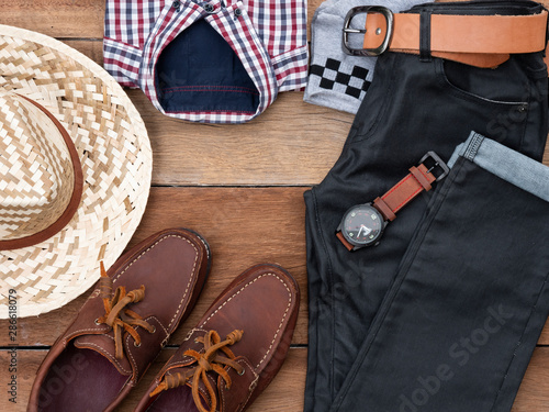 Flat lay, top view, men fashion casual clothing set on wooden background include boat shoes, jeans, belt ,watch, sunglass, hat, sock and shirt.